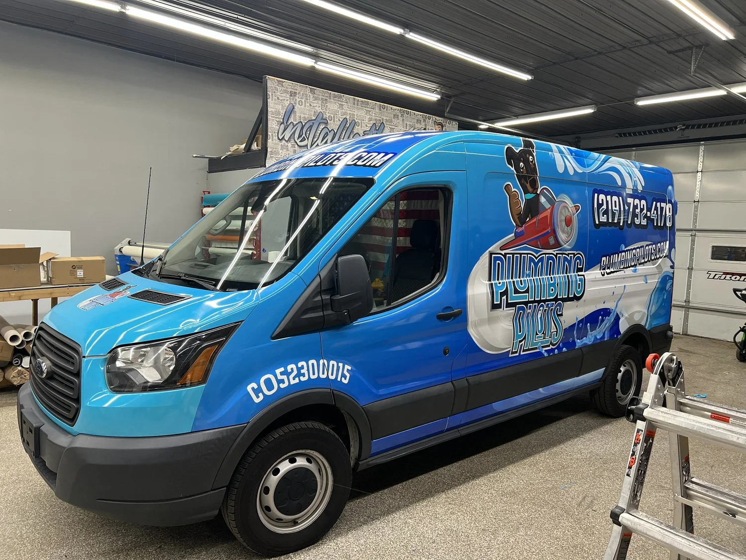 A blue Plumbing Pilots commercial van with custom wrap graphics